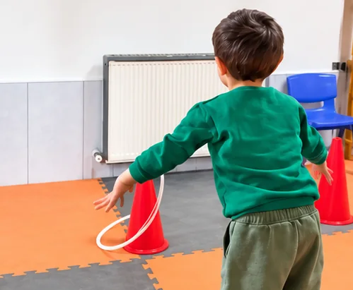 Spor salonunda çemberle oynayan çocuk